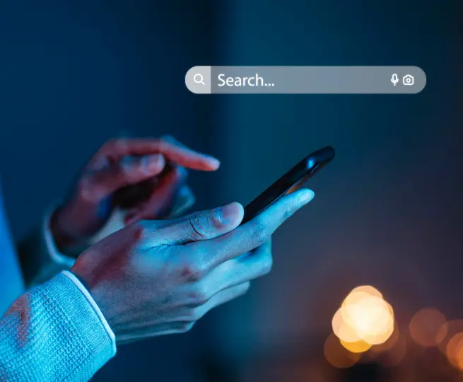 Person using smartphone search function at night.