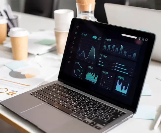 Laptop displaying graphs and analytics data on screen.